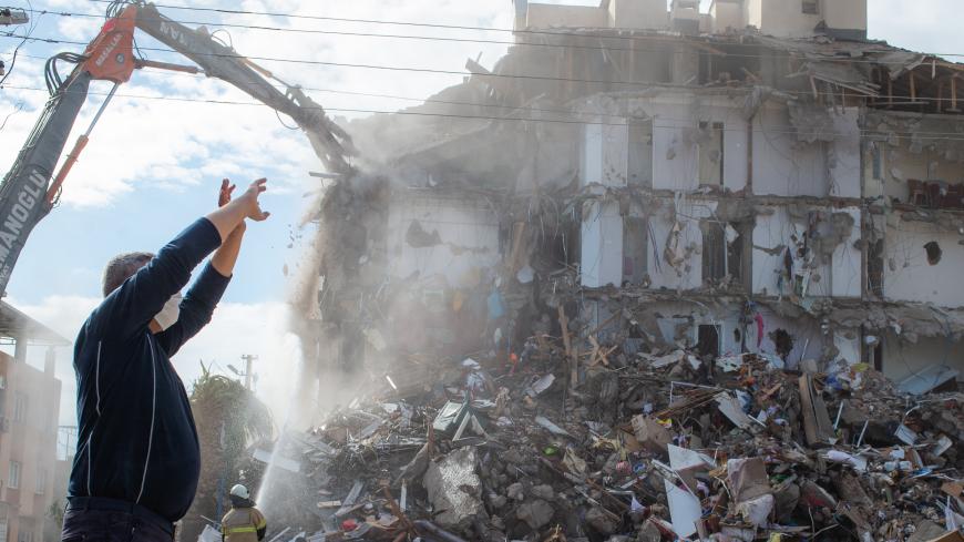 A firefighter watches as a damaged building is demolished in a controlled manner during the ongoing search operation for survivors and victims at the site of a collapsed building in the city of Izmir on November 2, 2020, after a powerful earthquake struck Turkey's western coast and parts of Greece. - Rescue workers were searching eight buildings in Izmir despite dwindling hope for survivors, as the death toll of a powerful magnitude earthquake which hit western Turkey rose to 69. The 7.0-magnitude quake has