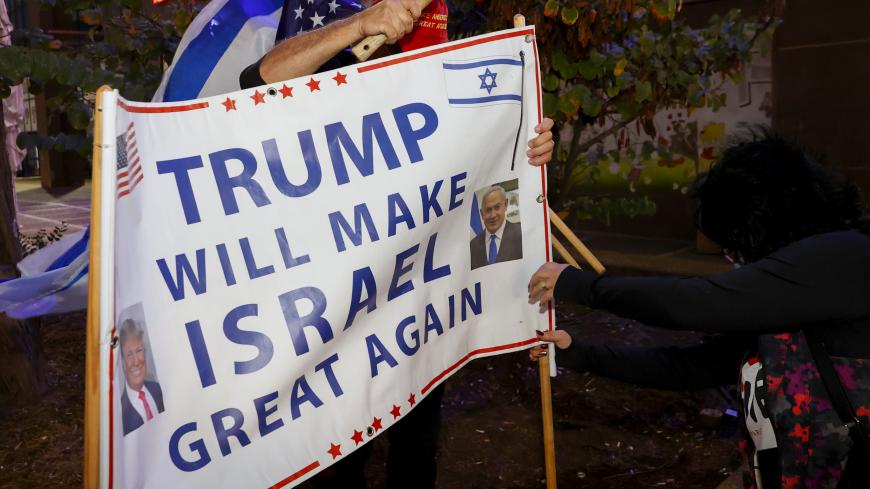 Israeli supporters of US President Donald Trump hammer a sign into the ground during a rally in the northern Israeli city of Karmiel near Haifa on November 3, 2020, to express their support for him during the US presidential election. (Photo by JACK GUEZ / AFP) (Photo by JACK GUEZ/AFP via Getty Images)