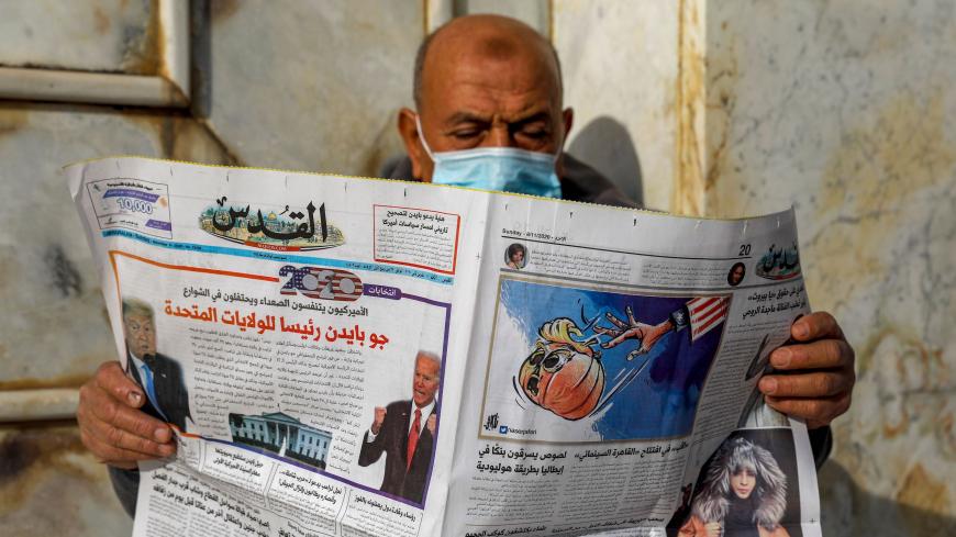 A Palestinian man reads the Al-Quds newspaper, headlined in Arabic "Joe Biden the new US President" outside the Dome of the Rock in the al-Aqsa mosque compound, Islam's third holiest site, in the old city of Jerusalem on November 8, 2020. (Photo by AHMAD GHARABLI / AFP) (Photo by AHMAD GHARABLI/AFP via Getty Images)