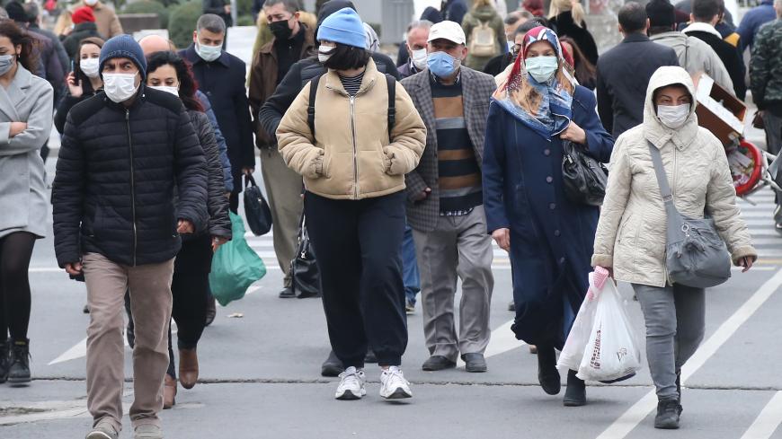 Pedestrians, wearing face masks, walk in a street of Ankara on November 20, 2020. - Turkey has set a new record on November 20, 2020, confirming 5,103 new COVID-19 patients and 141 deaths, the highest numbers since the start of the pandemic in the country. (Photo by Adem ALTAN / AFP) (Photo by ADEM ALTAN/AFP via Getty Images)