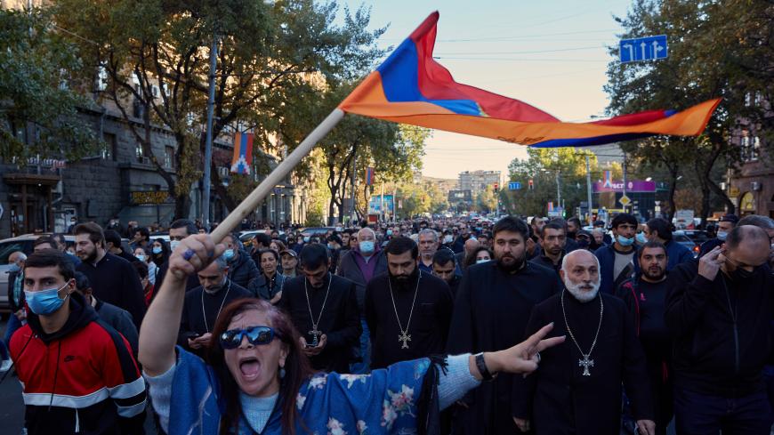 YEREVAN, ARMENIA - NOVEMBER 11: A woman waves an Armenian flag as protesters march to demand the removal of Armenian Prime Minister Nikol Pashinyan from office near the Armenian parliament building on November 11 2020 in Yerevan, Armenia. Opposition parties arranged a protest demanding the Prime Minister’s resignation after Armenia ceded large swathes of Nagorno-Karabakh to Azerbaijan following a six-weeks-long war over the contested territory.