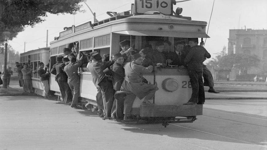 February 1936:  Passengers hanging on to the sides of a tram in Cairo.  (Photo by Fox Photos/Getty Images)