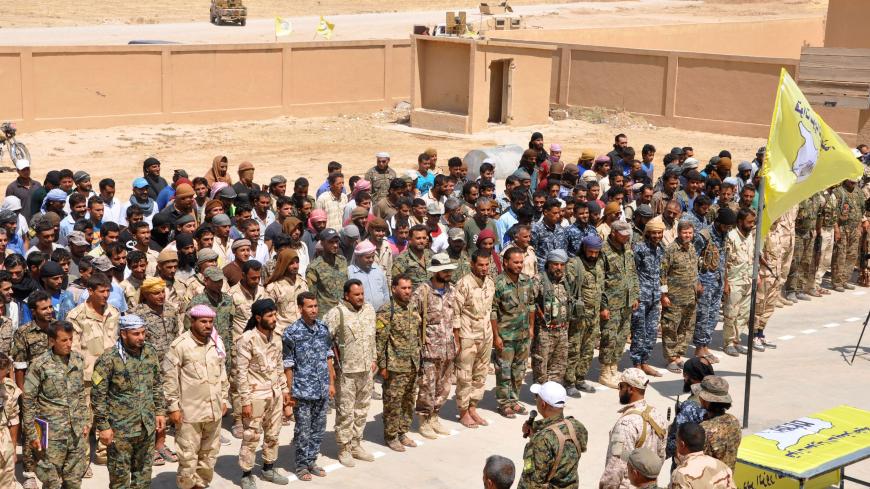 Members of the Deir Ezzor Military Council (DEMC), a coalition of Arab tribes and fighters that belongs to the broader US-backed Syrian Democratic Forces, stand in line during an announcement by their leader, Ahmed Abu Khawlah (bottom-C), in the town of Shadadi, about 60 kilometres (37 miles) south of the northeastern Syrian city of Hassakeh, on August 25, 2017.
The US-backed Arab and Kurdish fighters said on August 25, 2017 that they would launch an offensive "very soon" to oust the Islamic State (IS) grou