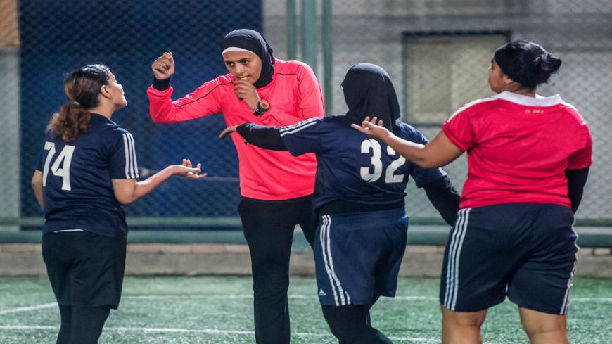 Egyptian referee Hanan Hassan (C-L, behind) blows a whistle while gesturing during a women football match in Cairo on June 3, 2018. - In April, the Egyptian Football Association's referee committee allowed Atalla and her female colleague Pousy Said to officiate a match in the second and third division leagues. The progress paves the way to allow women to participate in the men's premier league. But as the female referees are fighting to gain more ground, some female players actually object to their presence