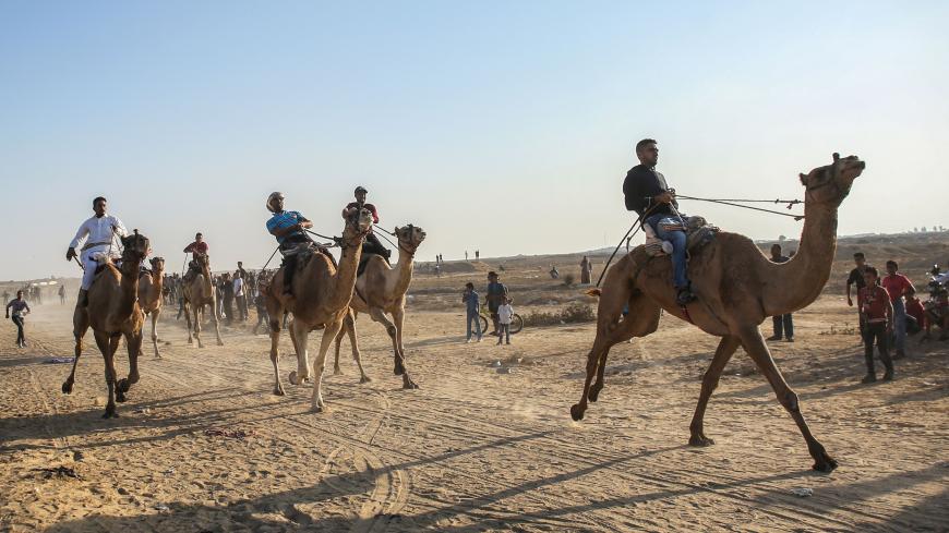 Palestinian jockeys compete during a local camel race held at the destroyed Gaza airport, in Rafah in the southern Gaza Strip on October 20, 2019. (Photo by SAID KHATIB / AFP) (Photo by SAID KHATIB/AFP via Getty Images)