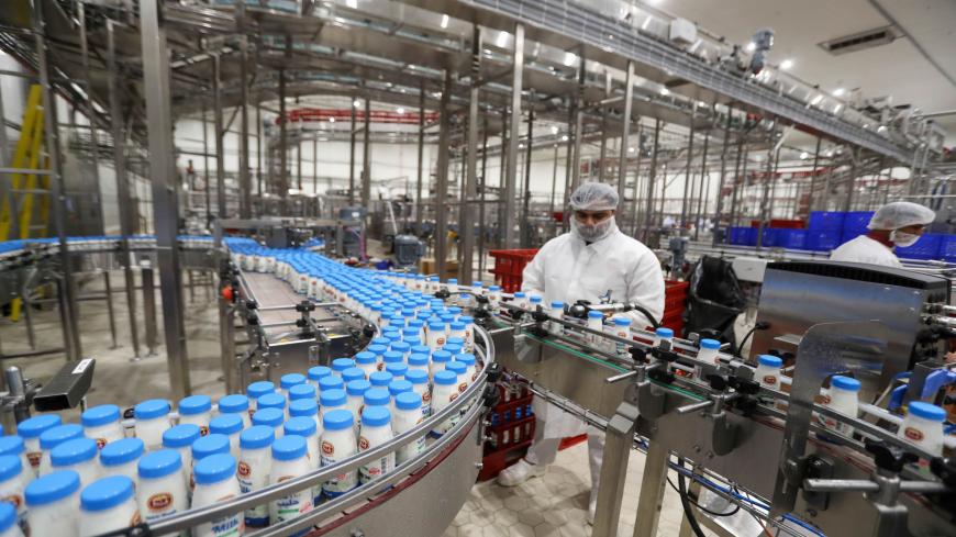 A worker inspects bottles of milk on on the producion line at a dairy factory at Baladna farm in the city of al-Khor, 60 kilometers north of the Qatari capital on October 26, 2019. - The cows of Qatar's Baladna farm, housed in climate-controlled farms in the desert, exemplify the lengths to which Qatar has gone to resist what it calls an economic "blockade" enforced by its Saudi-led neighbours. (Photo by KARIM JAAFAR / AFP) (Photo by KARIM JAAFAR/AFP via Getty Images)