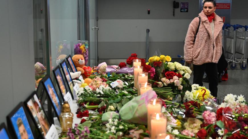 A woman stands in front of a makeshift memorial at the Boryspil airport outside Kiev, on January 11, 2020, as she pays tribute for the victims of the Ukraine International Airlines Boeing 737-800 that crashed near the Iranian capital Teheran. - Ukraine demanded on January 11, 2020 that Iran punishes those guilty for the downing of a Ukrainian airliner and compensate victims while praising Tehran for cooperating with the "objective" investigation. (Photo by Sergei SUPINSKY / AFP) (Photo by SERGEI SUPINSKY/AF