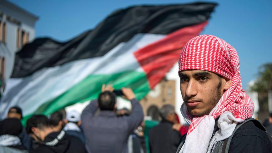 A Moroccan man walks next to a Palestinian flag during a demonstration against the US Middle East peace plan in the capital Rabat on February 9, 2020. - Morocco has warming but quiet relations with Israel, although they do not enjoy formal diplomatic ties. Israel and Morocco opened "liaison" offices in each other's countries in the mid-1990s but Rabat closed them after an escalation of Palestinian-Israeli violence in 2000. (Photo by FADEL SENNA / AFP) (Photo by FADEL SENNA/AFP via Getty Images)