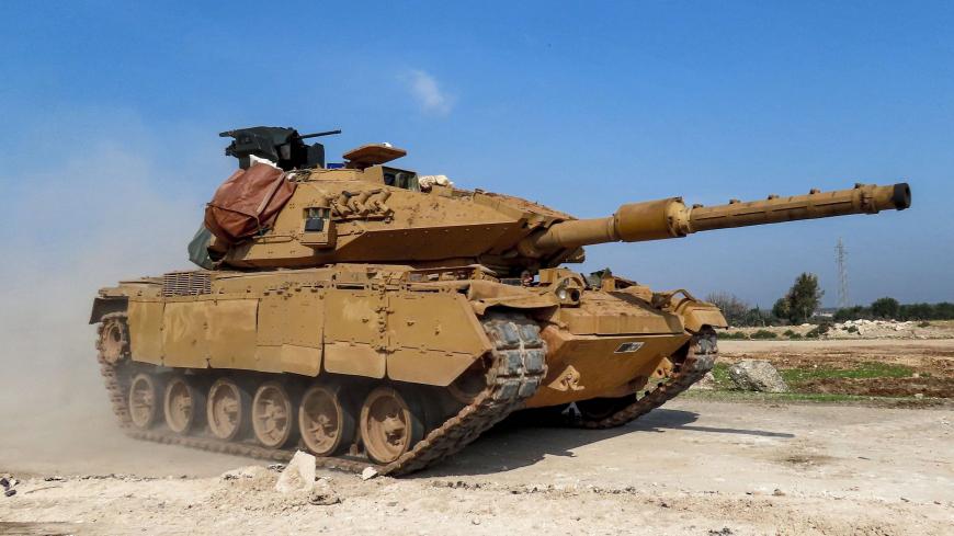 A Turkish military M60T battle tank is seen along the M4 highway, which links the northern Syrian provinces of Aleppo and Latakia, before incoming joint Turkish and Russian military patrols (as per an earlier agreed upon ceasefire deal) in the village of al-Nayrab, about 14 kilometres southeast of the city of Idlib and seven kilometres west of Saraqib in northwestern Syria on March 15, 2020. - Russian President Vladimir Putin and his Turkish counterpart Recep Tayyip Erdogan reached a deal on March 5 to crea
