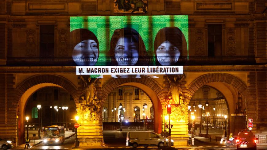 This picture taken early on November 19, 2020, shows a projection on the Louvre Museum in Paris by Amnesty International members depicting jailed Saudi human rights activists including Loujain Al-Athloul (C) and reading "Mr Macron, demand their release", ahead of the upcoming virtual G20 summit. (Photo by THOMAS COEX / AFP) (Photo by THOMAS COEX/AFP via Getty Images)