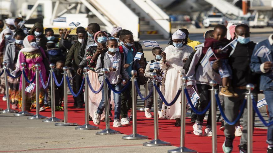 TEL AVIV, ISRAEL - DECEMBER 03: Newly arrived Jewish Ethiopian immigrants walk on a red carpet upon landing in Israel on a special flight from Ethiopia on December 3, 2020 in Tel Aviv, Israel. Several hundred members of the Falash Mura community of Ethiopian Jews arrived in Israel as part of ongoing relocation initiative. Ethiopian Israeli activists are pressing the Israeli government to admit more Ethiopian Jews to resettle there, to escape persecution at home. Israel generally recognizes the Falash Mura a