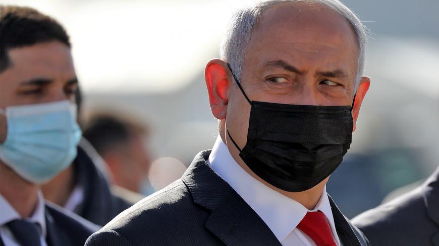 Israeli Prime Minister Benjamin Netanyahu attends a ceremony to mark the arrival of a plane of the international courier company DHL, carrying over 100,000 of doses of the first batch of Pfizer vaccines which landed at Ben Gurion Airport near Tel Aviv, on December 9, 2020. - According to media reports, the launch of a national COVID-19 immunisation campaign is set to begin on December 20. (Photo by Abir SULTAN / POOL / AFP) (Photo by ABIR SULTAN/POOL/AFP via Getty Images)