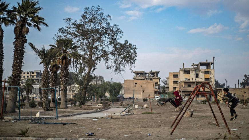 TOPSHOT - Boys play on the swings in the northern Syrian city of Raqa, the former Syrian capital of the Islamic State (IS) group, on December 20, 2020. - The Kurdish-led Syrian Democratic Forces overran Raqa in 2017, after years of what residents described as IS's brutal rule, which included public beheading and crucifixions. (Photo by Delil SOULEIMAN / AFP) (Photo by DELIL SOULEIMAN/AFP via Getty Images)