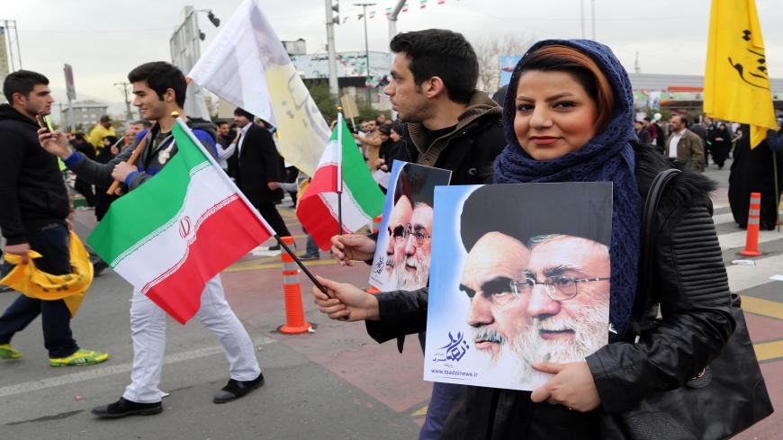 Iranians hold their national flag and posters bearing portraits of Supreme Leader, Ayatollah Ali Khamenei (R) and the founder of Iran's Islamic Republic, Ayatollah Ruhollah Khomeini (L) during a rally in Tehran's Azadi Square (Freedom Square) to mark the 36th anniversary of the Islamic revolution on February 11, 2015. Iranians gathered in cities and villages all over the country to mark the 36th anniversary of the revolution which transformed the country from a US-backed monarchy into a cleric-ruled republi