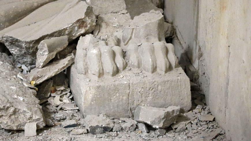 The remains of carved feet of a "Lamassu" statue, an Assyrian deity often depicted as a winged-bull with a human head, stands inside the destroyed museum of Mosul on April 2, 2017 after Iraqi forces recaptured it from Islamic State (IS) group fighters. 
Iraqi forces seized the museum from IS on March 7 as they pushed into west Mosul as part of a vast offensive to oust the jihadists from the northern city. / AFP PHOTO / AHMAD GHARABLI        (Photo credit should read AHMAD GHARABLI/AFP via Getty Images)
