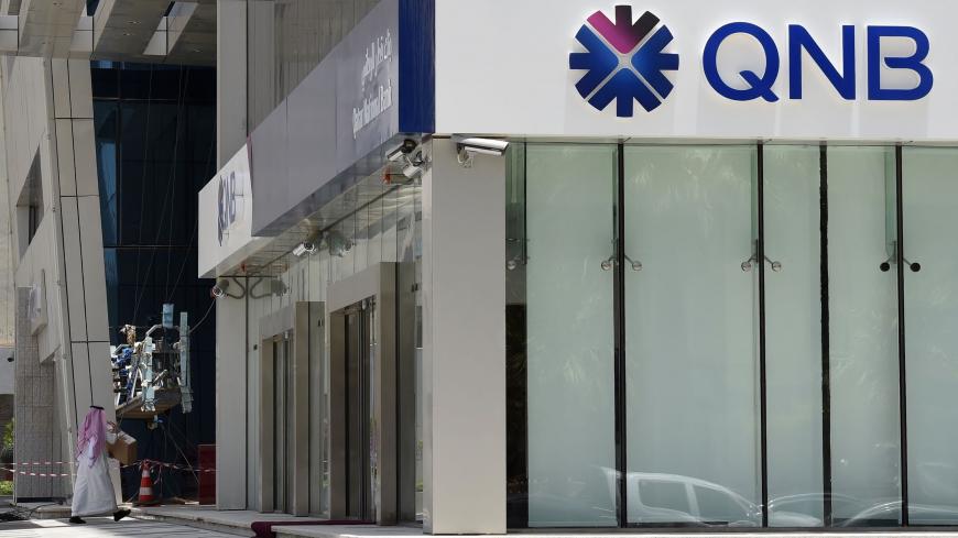 A picture taken on June 5, 2017 shows a man walking past the Qatar National Bank (QNB) branch in the Saudi capital Riyadh, following a severing of relations between major gulf states and gas-rich Qatar. - Arab nations including Saudi Arabia and Egypt cut ties with Qatar accusing it of supporting extremism, in the biggest diplomatic crisis to hit the region in years. (Photo by FAYEZ NURELDINE / AFP) (Photo by FAYEZ NURELDINE/AFP via Getty Images)