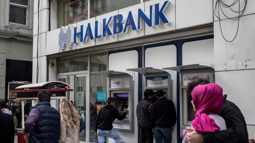ISTANBUL, TURKEY - DECEMBER 01: People walk past a branch of Turkish bank HalkBank on December 1, 2017 in Istanbul, Turkey. The trial of Mr. Reza Zarrab, an Iranian-Turk who ran a foreign exchange and gold dealership continues in New York. In recent days testimony Mr. Zarrab implicated a number of Turkish Banks as well as high ranking government officials. Mr. Zarrab is accused of managing a billion-dollar scheme to smuggle gold for Iranian oil and conspiring to violate United States sanctions against Iran.