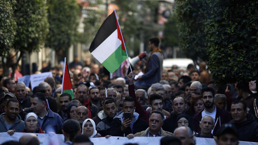 Palestinians wave national flags as they march in the streets of the occupied West Bank city of Ramallah, calling for the cessation of divisions between Fatah and Hamas and the unification of the West Bank and Gaza Strip, on January 12, 2019. (Photo by ABBAS MOMANI / AFP)        (Photo credit should read ABBAS MOMANI/AFP via Getty Images)
