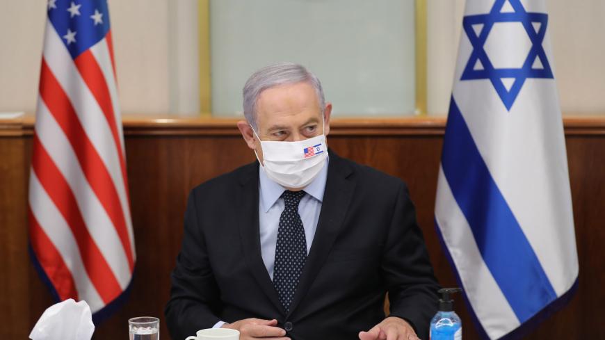 Israeli Prime Minister Benjamin Netanyahu wears a face mask against Covid-19, bearing the US and Israeli flags, during a meeting with US special representative for Iran at the prime minister's office in Jerusalem on June 30, 2020. (Photo by ABIR SULTAN / POOL / AFP) (Photo by ABIR SULTAN/POOL/AFP via Getty Images)