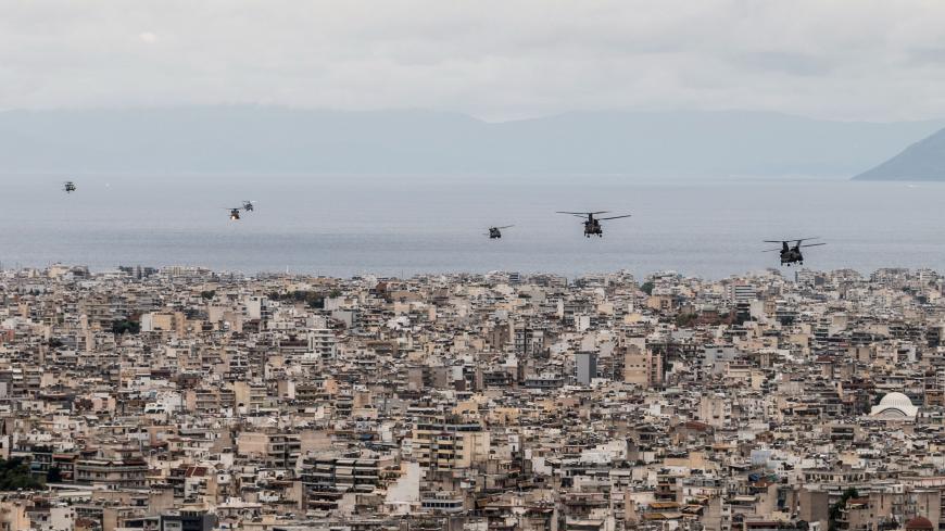 Hellenic Air Force helicopters fly over buildings in Athens on October 28, 2020, during celebrations marking Greece's National "Oxi" (No) Day, commemorating Greece's refusal to accept the ultimatum advanced by fascist Italy in 1940 during World War II. (Photo by Angelos Tzortzinis / AFP) (Photo by ANGELOS TZORTZINIS/AFP via Getty Images)