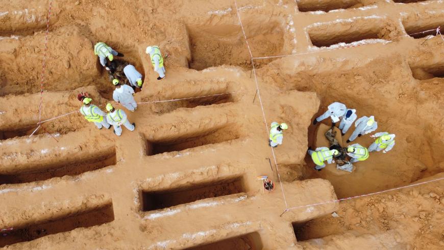 This picture taken on November 7, 2020 shows an aerial view of members of the public body leading the "Search and Identification of the Missing," backed by the UN-recognised Government of National Accord (GNA), unearthing a mass grave site in western Libya's Tarhuna region. - Seventeen bodies have been unearthed in newly found mass graves in Tarhuna, taking the total exhumed in recent months to 112, the missing persons authority said on November 7. The graves are located in the region from where eastern str