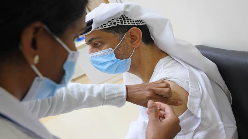 An Emirati man gets vaccinated against the COVID-19 coronavirus at al-Barsha Health Centre in the Gulf Emirate of Dubai on December 24, 2020. (Photo by GIUSEPPE CACACE / AFP) (Photo by GIUSEPPE CACACE/AFP via Getty Images)