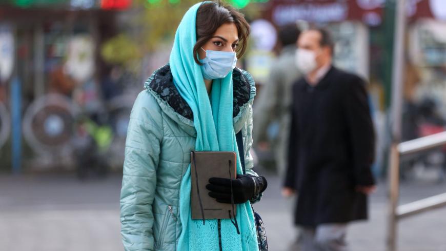 An Iranian woman wearing a protective mask amid the COVID-19 pandemic, walks on a street in the capital Tehran, on December 30, 2020. (Photo by ATTA KENARE / AFP) (Photo by ATTA KENARE/AFP via Getty Images)
