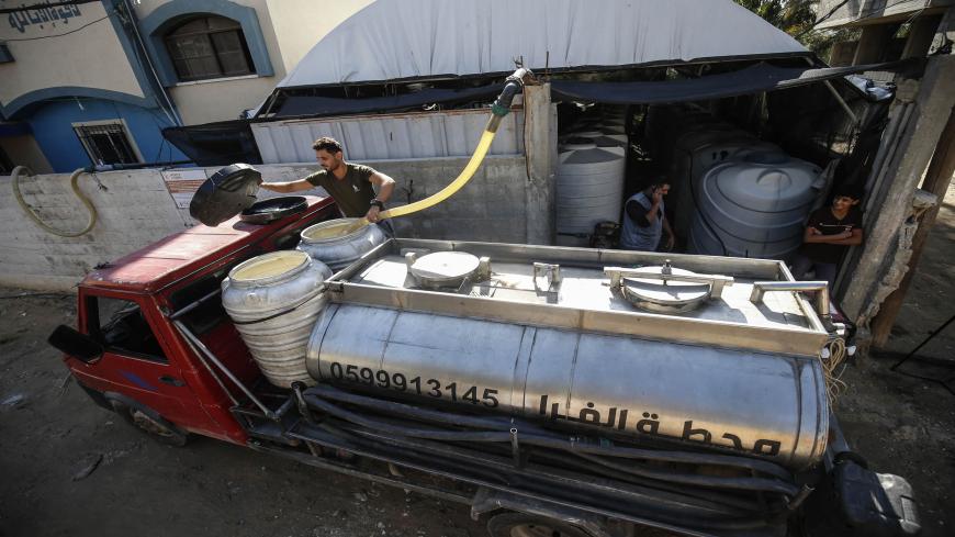 A Palestinian workers fills up a truck transporting water from a freshwater plant that extracts water from wells and sells to people in the town of Khan Yunis in southern Gaza Strip, on November 18, 2020. - The densely-populated Gaza Strip has long lacked sufficient drinking water, but a new project helps ease the shortage with a solar-powered process to extract potable water straight from the air. (Photo by SAID KHATIB / AFP) (Photo by SAID KHATIB/AFP via Getty Images)