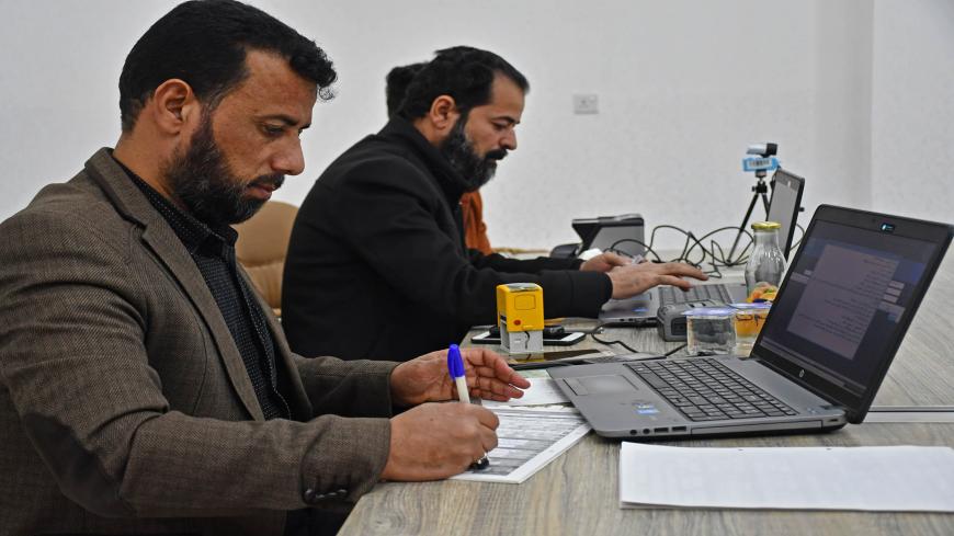Employees of Iraq's Independent High Electoral Commission Center register voters in the southern Iraqi city of Nasiriyah in the Dhi Qar province, on January 12, 2021. - Iraq's early parliamentary elections were promised by the PM for June but according to officials and politicians they are highly unexpected to be held without several month of delay. (Photo by Asaad NIAZI / AFP) (Photo by ASAAD NIAZI/AFP via Getty Images)