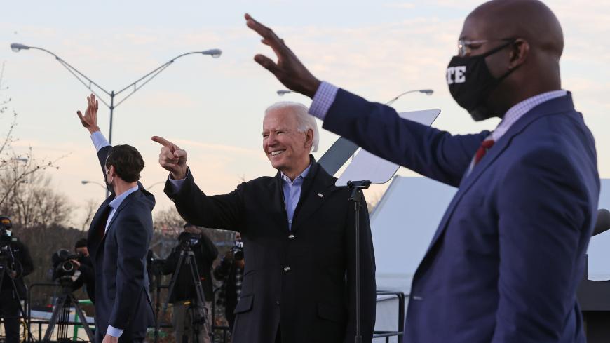 ATLANTA, GEORGIA - JANUARY 04: President-elect Joe Biden (C) rallys with Democratic candidates for the U.S. Senate Jon Ossoff (L) and Rev. Raphael Warnock (R) the day before their runoff election in the parking lot of Center Parc Stadium January 04, 2021 in Atlanta, Georgia. Biden's trip comes a day after the release of a recording of an hourlong call where President Donald Trump seems to pressure Georgia Secretary of State Brad Raffensperger to “find” the votes he would need to reverse the presidential ele