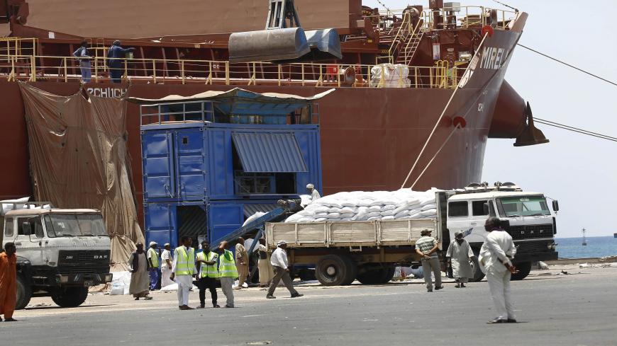 Sudanese dockers unload bags of sorgham (cereal) from one of two US ships carrying humanitarian aid supplies provided by the US development agency USAID, at Port Sudan on the red sea coast on June 5, 2018. - The United States is the largest single donor to the world food program in Sudan and regularly distributes food aid to the East African country. This shipment will be distributed to over a  million Sudanese who are in need of assistance. (Photo by ASHRAF SHAZLY / AFP)        (Photo credit should read AS