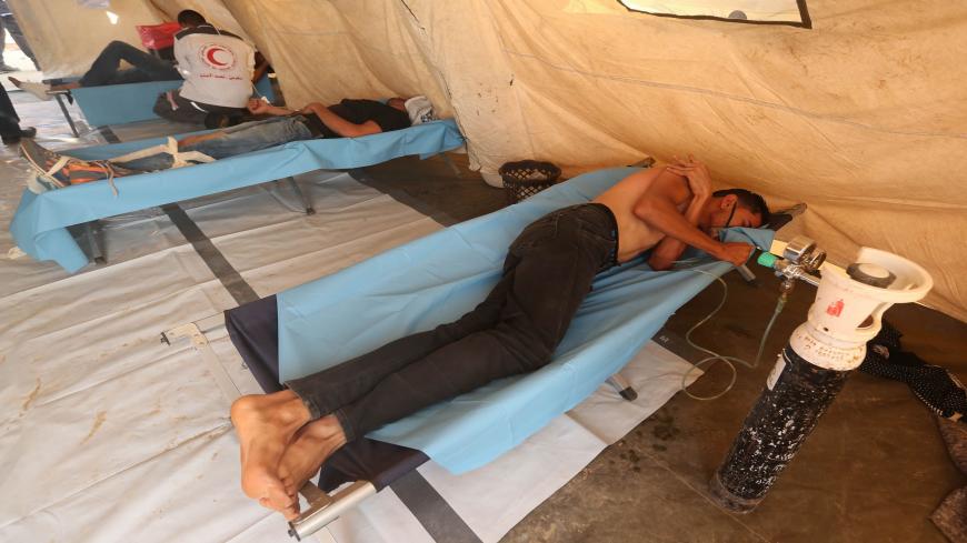 Palestinian protesters wounded during clashes with Israeli forces receive treatments from Red Crescent members in a field hospital during a demonstration along the border between the Gaza Strip and Israel, east of Gaza city on June 22, 2018. (Photo by MAHMUD HAMS / AFP)        (Photo credit should read MAHMUD HAMS/AFP via Getty Images)