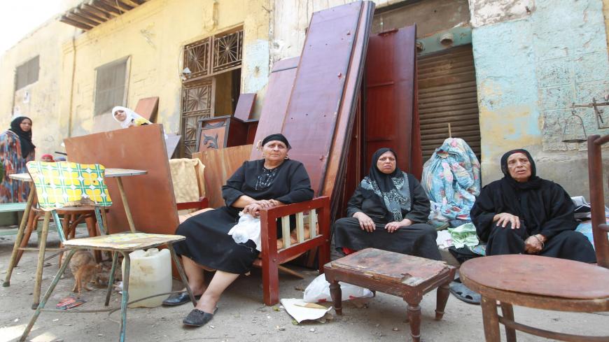 Egyptian women sit in the street with their furniture after they were evacuated from their home a few days ago on July 14, 2010, in the al-Darb el-Ahmar area in the historic Islamic Cairo. Several hundred meters (yards) away an old building collapsed overnight killing seven people sleeping inside. AFP PHOTO/KHALED DESOUKI (Photo credit should read KHALED DESOUKI/AFP via Getty Images)