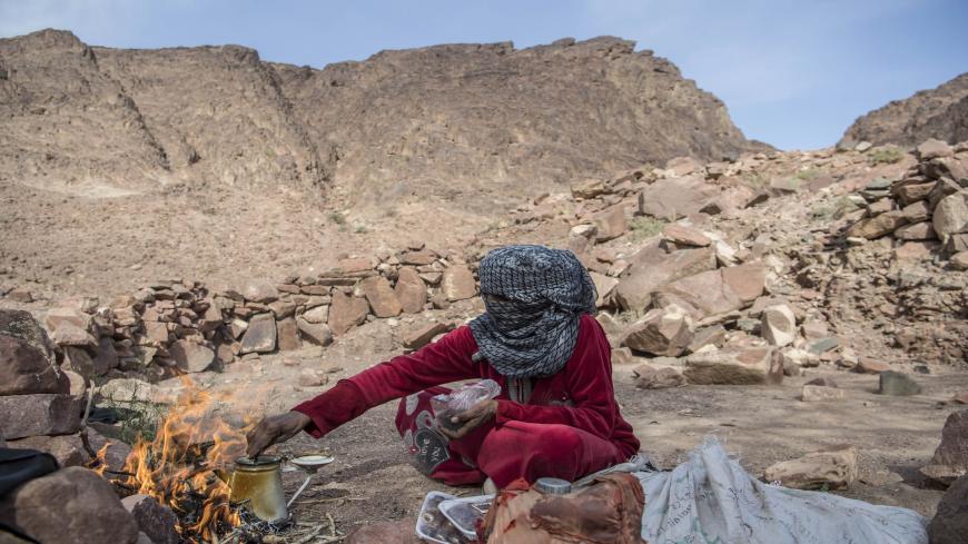 Umm Yasser, an Egyptian Bedouin woman guide from the Hamada tribe, prepares tea for a group of hikers in Wadi el-Sahu in South Sinai governorate on March 29, 2019, during the first "Sinai Trail" led by Bedouin women guides. - In Wadi Sahu, a village in the southern part of Egypt's eastern Sinai peninsula, made up of humble shacks with corrugated iron and recycled scraps, Bedouins are banking on the return of tourism after the tumultuous years since Egypt's 2011 uprising. (Photo by Khaled DESOUKI / AFP)     