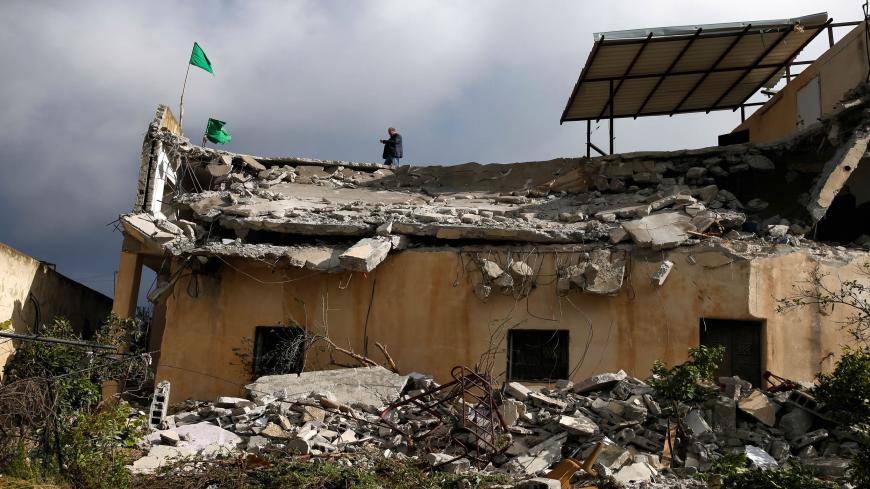 Hamas flags stand on the roof of the house of Palestinian assailant Salah Barghouti after it was partially demolished by Israeli forces in the village of Kobar near Ramallah, in the Israeli-occupied West Bank, on April 17, 2019. - Israeli forces destroyed the home of the Palestinian who was killed during his attempted arrest on suspicion of carrying out a December shooting. Seven people were wounded in the December 9 attack near the Israeli settlement of Ofra in the occupied West Bank, one of them a pregnan