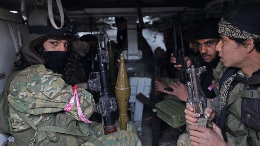 Members of the "Syrian National Army", an alliance of Turkey-backed rebel groups, ride in an armoured personnel carrier (APC) in the town of Sarmin, about 8 kilometres southeast of the city of Idlib in northwestern Syria, on February 24, 2020, as they take part in a military offensive on the village of Nayrab following an artillery barrage fired by Turkish forces. (Photo by Omar HAJ KADOUR / AFP) (Photo by OMAR HAJ KADOUR/AFP via Getty Images)