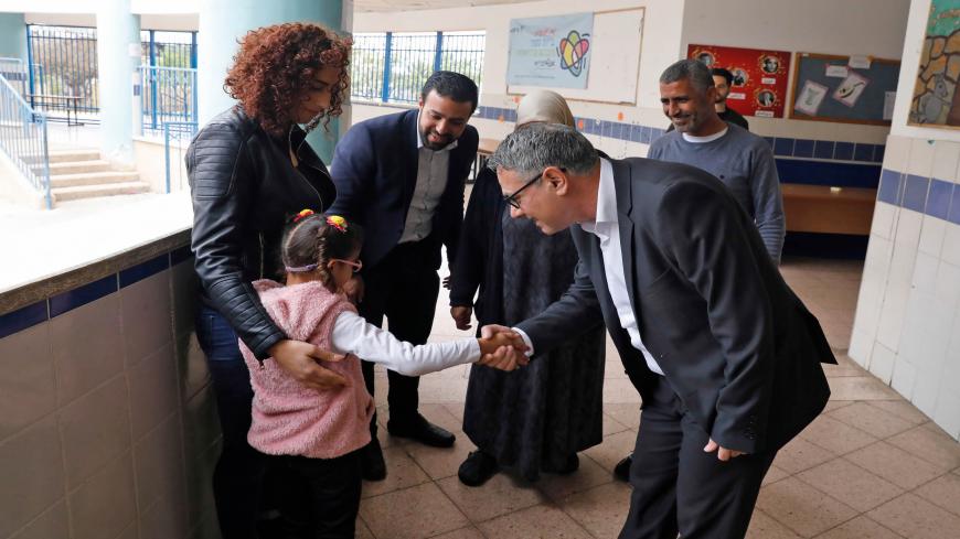Mtanes Shehadeh (R), an Arab-Israeli politician from the Joint List political alliance, greets a family at a polling station in the Arab city of Tamra in northern Israel on March 2, 2020. - Israelis were voting for a third time in 12 months today, with embattled Prime Minister Benjamin Netanyahu seeking to end the country's political crisis and save his career. (Photo by AHMAD GHARABLI / AFP) (Photo by AHMAD GHARABLI/AFP via Getty Images)