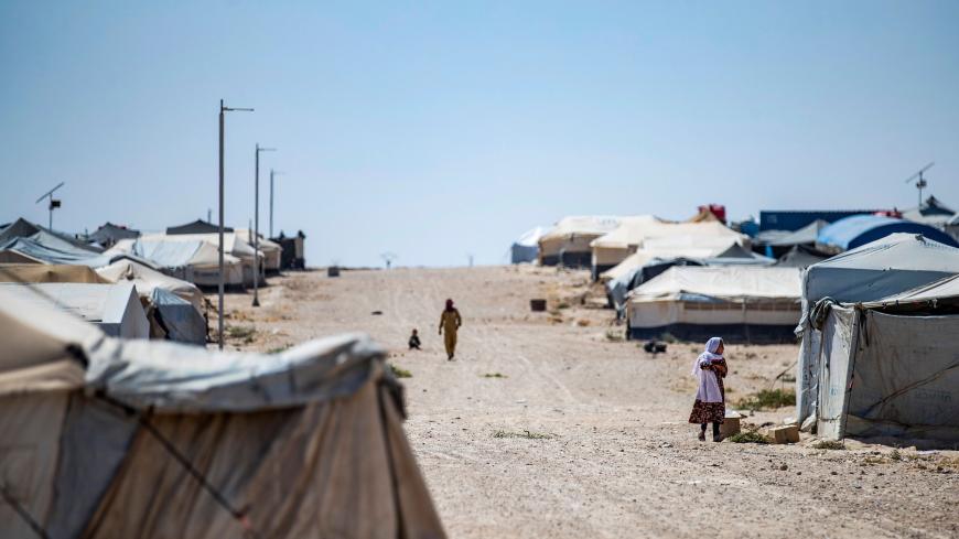 TOPSHOT - People walk past tents in the Kurdish-run al-Hol camp in the al-Hasakeh governorate in northeastern Syria on August 25, 2020, where families of Islamic State (IS) foreign fighters are held. (Photo by Delil SOULEIMAN / AFP) (Photo by DELIL SOULEIMAN/AFP via Getty Images)