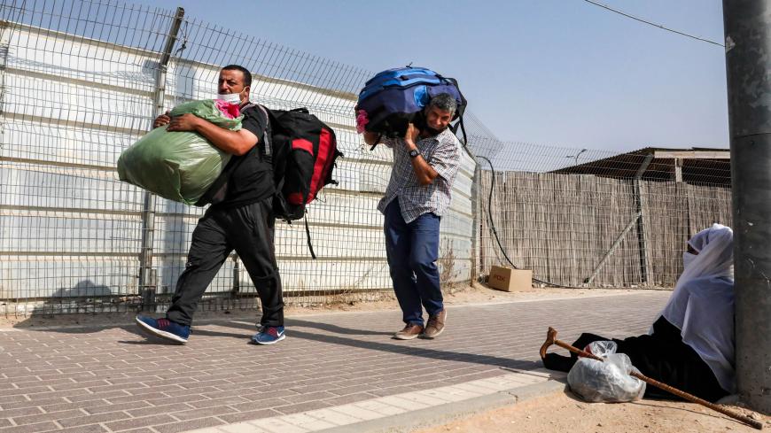 This picture taken from the Israeli side of the Mitar checkpoint on September 17, 2020 shows Palestinian workers crossing out of Israel a day ahead of Rosh-Hashana (the Jewish New Year) and of a nationwide lockdown aimed at curbing a spike of coronavirus cases. - Israel has the world's second-highest virus infection rate after Bahrain, according to an AFP tally over the past fortnight, and on September 18 it is set to be the first country to impose a second lockdown. (Photo by HAZEM BADER / AFP) (Photo by H