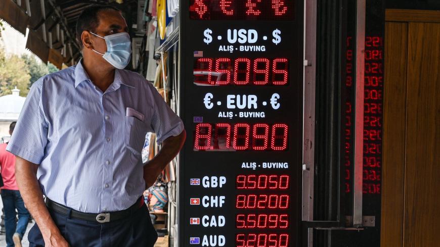 A man waits in front of a currency exchange agency as a screen shows rates near Grand bazaar, in Istanbul, on September 24, 2020. - Turkey's central bank on September 24, 2020 raised its main interest for the first time since September 2018, boosting the rate by two percentage points to help the lira recover from historic lows. (Photo by Ozan KOSE / AFP) (Photo by OZAN KOSE/AFP via Getty Images)
