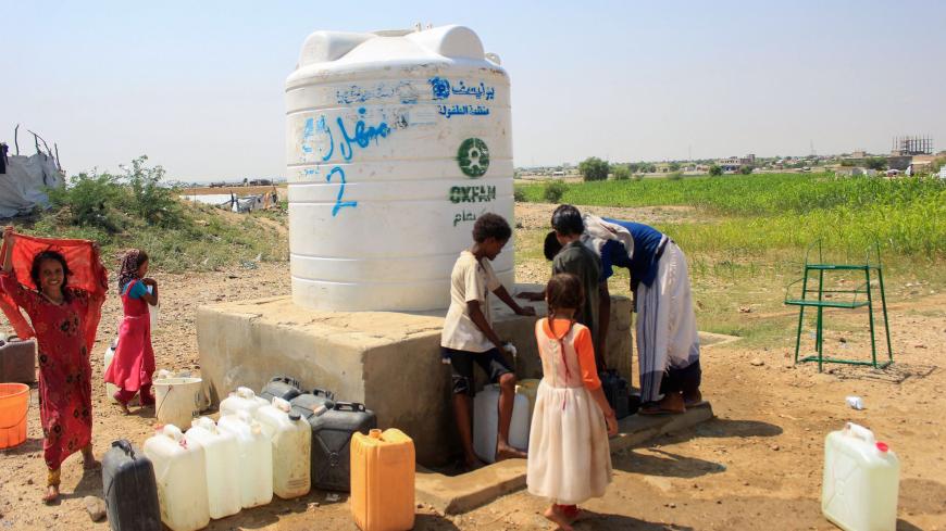 Yemeni children fill jerrycans with water from a cistern at a camp for internally displaced people by conflict in the northern Hajjah province on October 12, 2020. (Photo by ESSA AHMED / AFP) (Photo by ESSA AHMED/AFP via Getty Images)