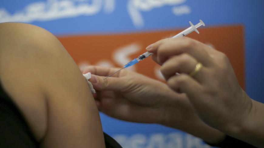 A Druze woman gets vaccinated against the COVID-19 coronavirus at the Kupat Holim Meuhedet clinic in the Druze village of Ein Quniya in the Israeli-annexed Golan Heights on January 13, 2021. (Photo by JALAA MAREY / AFP) (Photo by JALAA MAREY/AFP via Getty Images)