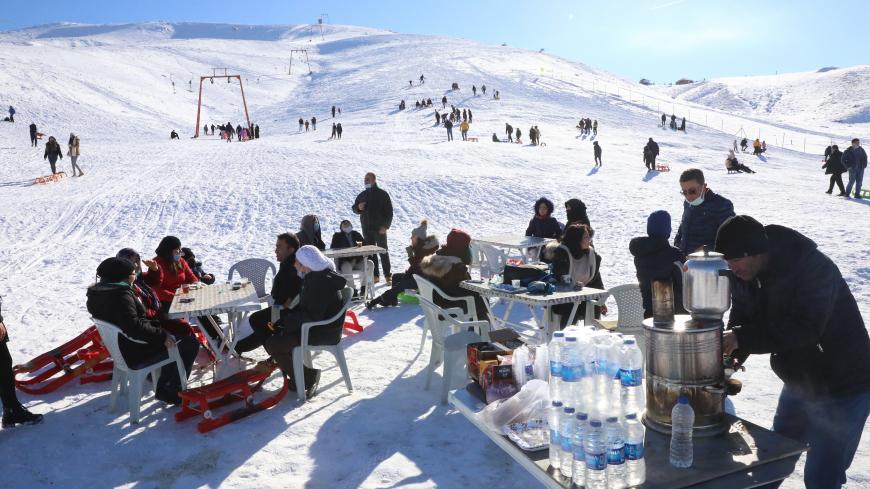 People sit at tables, at the Elmadag Ski Resort in Ankara, on January 22, 2021, after a snowfall. (Photo by Adem ALTAN / AFP) (Photo by ADEM ALTAN/AFP via Getty Images)
