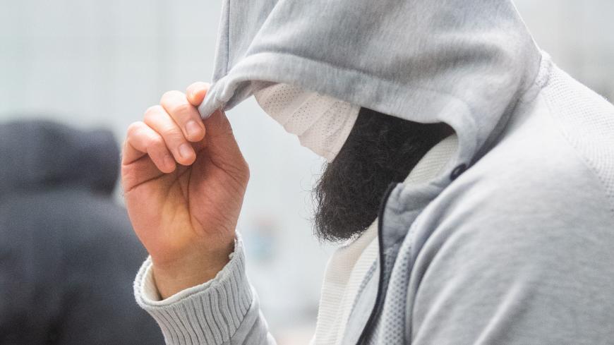 Iraqi defendant Abu Walaa, described as the Islamic State group's de facto leader in Germany, hides his face as he arrives at court for the verdict of his trial on February 24, 2021 in Celle, central Germany. - A German court hands down on february 24 its ruling in a case against Abu Walaa, a notorious Iraqi preacher believed to be the Islamic State jihadist group's de facto leader in Germany. Ahmad Abdulaziz Abdullah Abdullah, better known as Abu Walaa, is accused of being "IS' representative in Germany" a