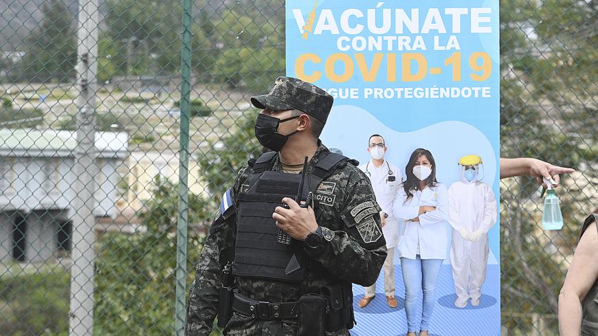 A member of the Honduran Army observes as health workers begin the vaccination against COVID-19 with the Moderna vaccines in Tegucigalpa, on February 25, 2021. (Photo by Orlando SIERRA / AFP) (Photo by ORLANDO SIERRA/AFP via Getty Images)