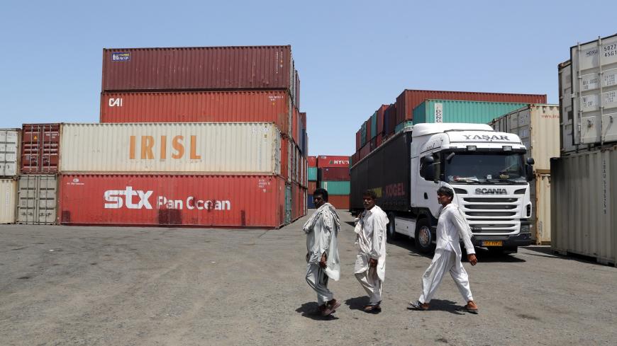 TO GO WITH AFP STORY OF CYRIL JULIEN 
Iranian workers walk near containers at the Kalantari port in city of Chabahar on May 12, 2015. Chabahar, located on the coast of Sistan-Baluchistan (south-east), is open to the Oman Sea and the Indian Ocean. It is Iran's gateway to Pakistan and Afghanistan in the east, the Central Asian countries to the north, and Turkey and the Gulf countries in the west. AFP PHOTO / ATTA KENARE        (Photo credit should read ATTA KENARE/AFP via Getty Images)