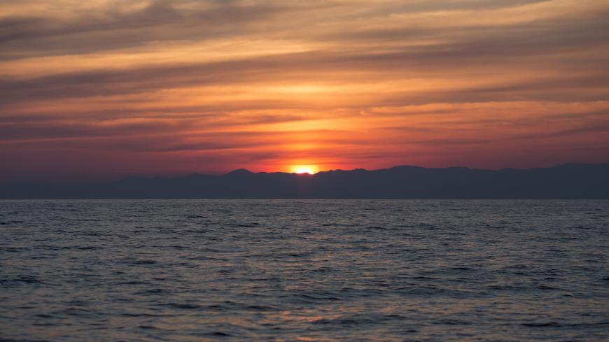 AT SEA - MARCH 30:  The sun rises over the Turkish coastline as Portuguese Frontex crew monitor the Aegean sea between Turkey and Greece for boats carrying refugees on March 30, 2016 near Mithymna, Greece. Frontex is a European Union border agency and was established in 2004 to manage the cooperation between national border guards in securing their external borders. New arrivals of refugees and migrants on the island of Lesbos have reduced dramatically to almost non over the last week, since a deal between 