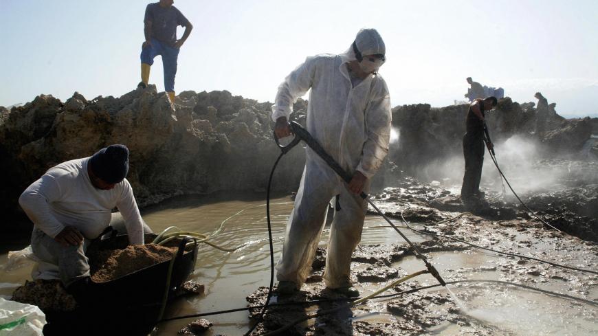 Lebanese workers use water pressure to clean-up the oil spill which polluted the Rabbit Island, offshore the Nothern Lebanese city of Tripoli, on March 31, 2009. The oil spill was caused by the explosion of fuel reservoirs stationed in the southern coastal town of Jiyyeh during the Israeli offensive on Lebanon in July 2006. At least 10,000 tons of heavy fuel oil have been spilled into the Lebanese sea, causing an environmental catastrophe with severe effects on health, biodiversity and tourism. The oil spil