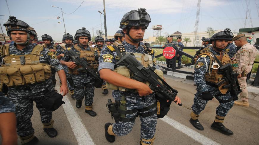 Iraqi security forces guard a symbolic funeral procession attended by high-ranking officials in Baghdad on October 23, 2019 for Major General Ali al-Lami, a commander of the Iraqi Federal Police's Fourth Division, who was killed the previous day in Samarra in the province of Salahuddin, north of the Iraqi capital. - The police commander was killed in an ambush on October 22 which Iraqi security forces blamed on dormant cells of the Islamic State (IS) group. (Photo by AHMAD AL-RUBAYE / AFP) (Photo by AHMAD A