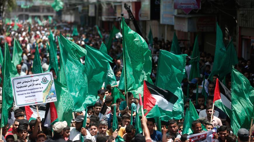 Palestinian supporters of the Hamas movement wave flags as they rally against Israel's plans to annex parts of the occupied West Bank, in Jabalia refugee camp in northern Gaza Strip, on June 19, 2020. - Israel intends to annex West Bank settlements and the Jordan Valley, as proposed by US President Donald Trump, with initial steps slated to begin from July 1. (Photo by MAHMUD HAMS / AFP) (Photo by MAHMUD HAMS/AFP via Getty Images)